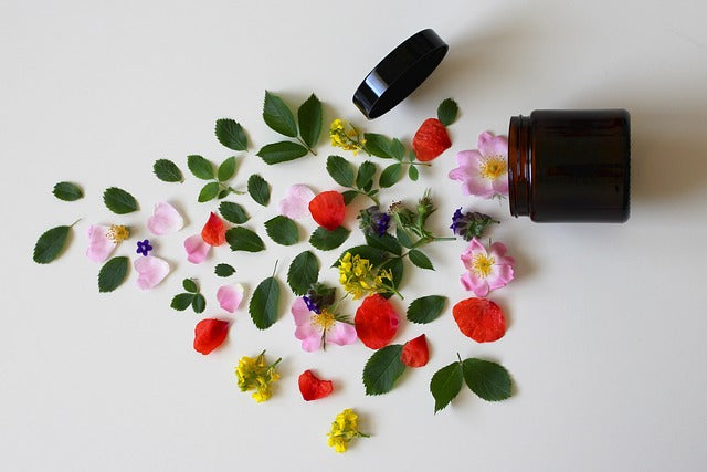 flowers, leaves and petals spilling out of a skincare tub 