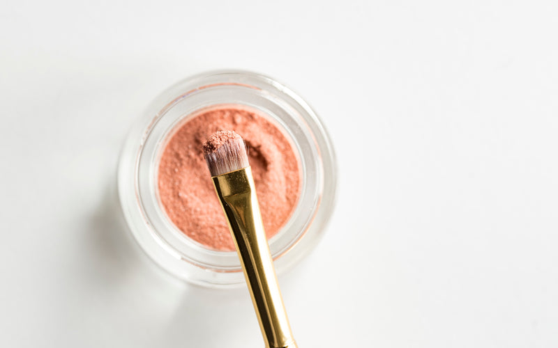 best beauty hacks makeup brush with glass pot of pink powdered makeup 