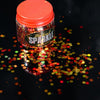 pot of orange and yellow face glitter