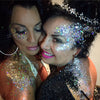 two women wearing silver glitter on their faces and in their hear