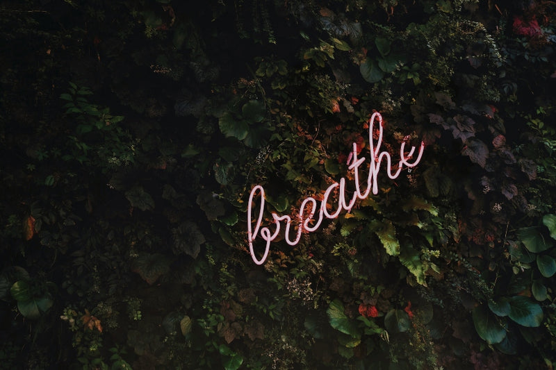 Neon pink sign that says breathe, which is one of the best simple self care ideas