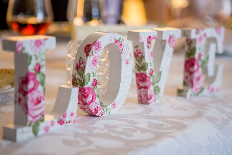 Looking for fun wedding reception ideas? Floral love sign used as decoration on table