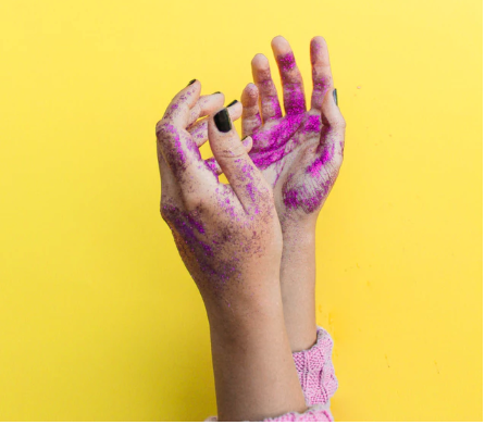 is glitter safe? pink glitter on hands and a yellow background