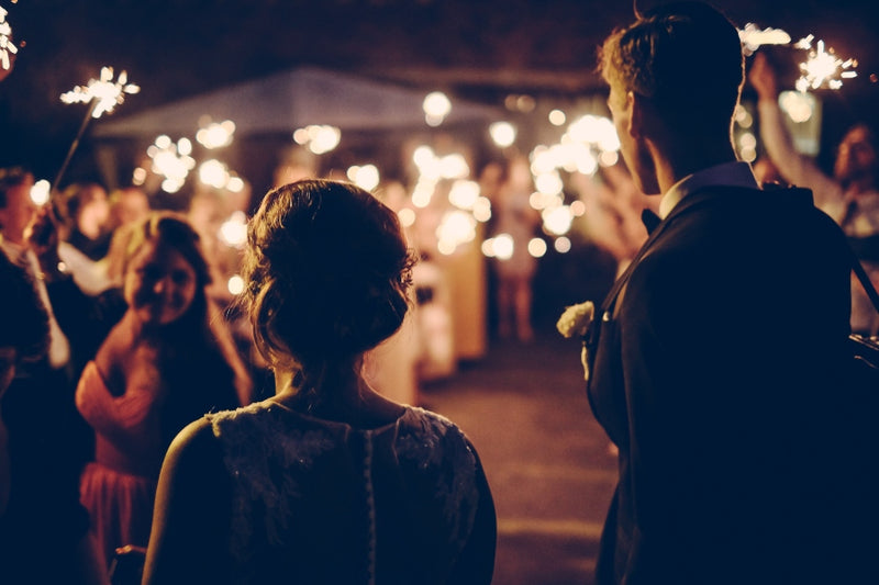 A bride and groom surrounded by sparklers as an alternative wedding entertainment ideas