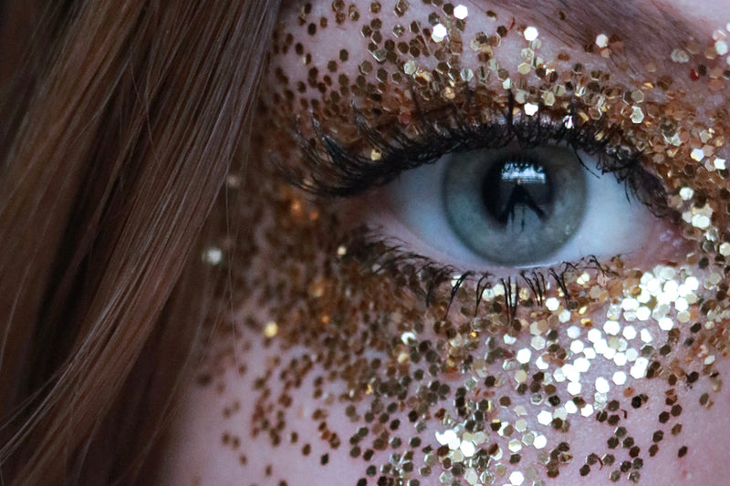 Close up of a woman wearing guilt free glitter around her eye as makeup 