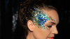woman wearing blue glitter on her face and into her hair 