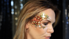 woman wearing orange and yellow face glitter in her hair 